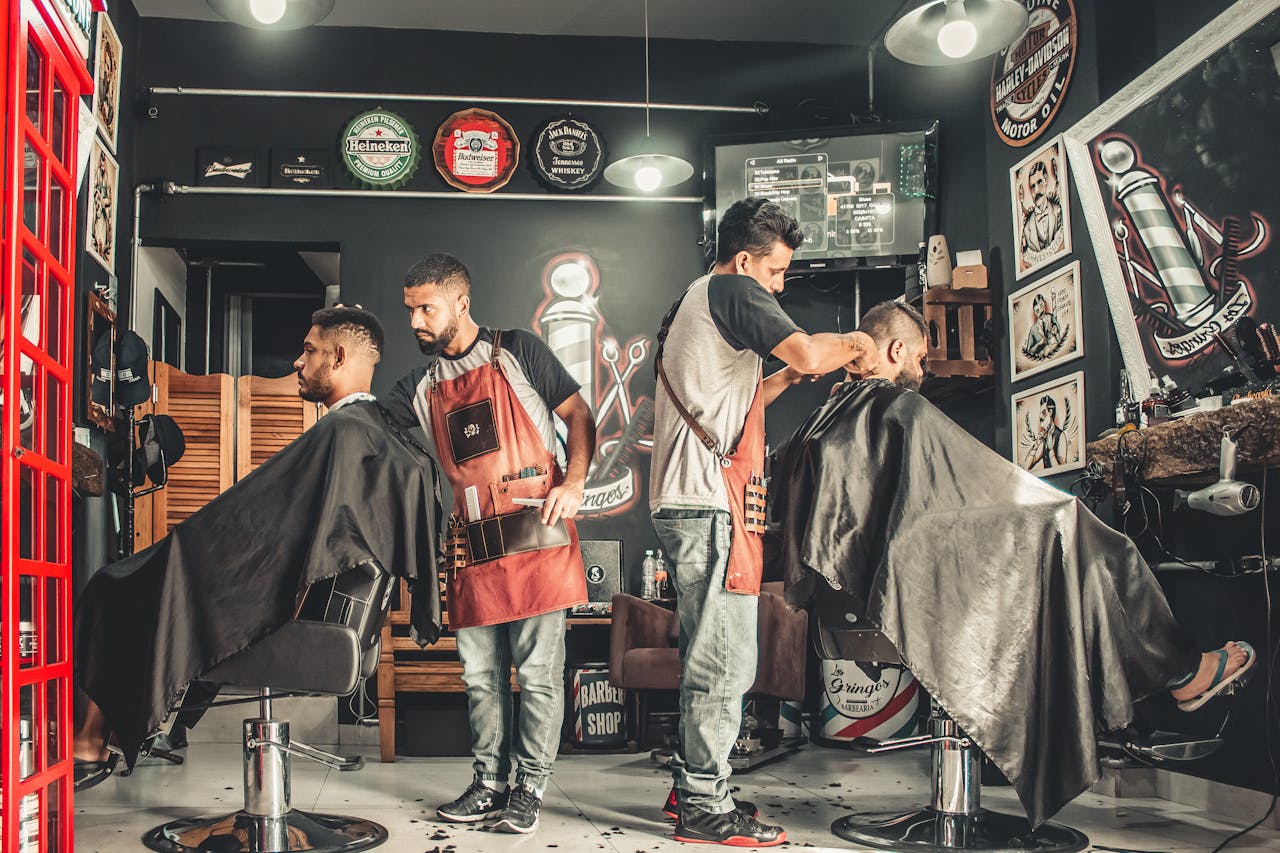 ours-journey A bustling barbershop with two men getting haircuts, showcasing a vibrant barber environment.