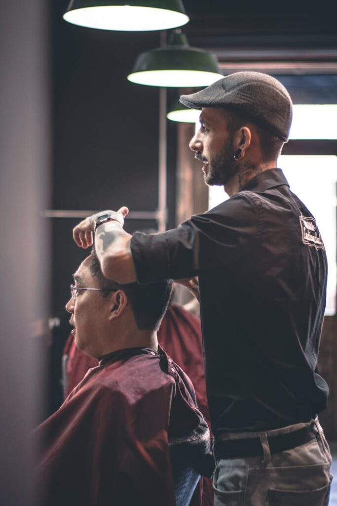 Barber skillfully trims customer's hair in a modern salon, capturing hairstyle expertise.